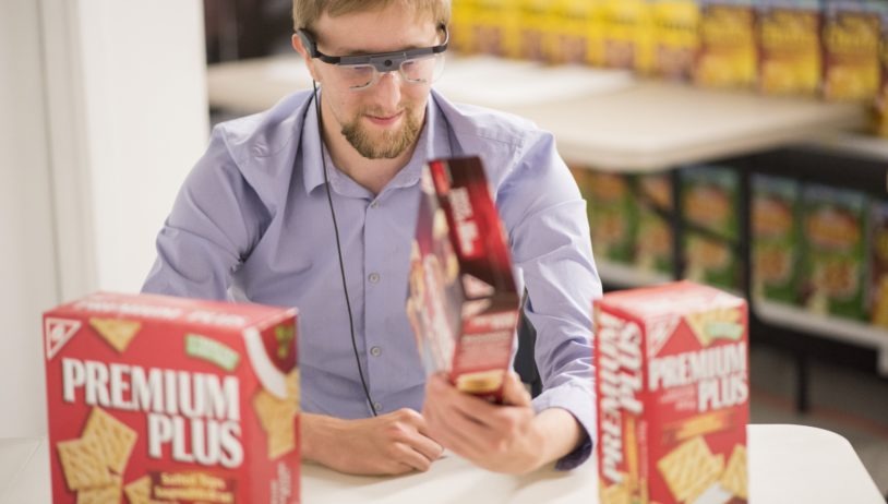 man wearing eye tracking glasses looking at box of crackers