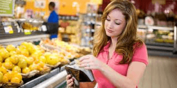woman in a grocery store looking through cards in her purse